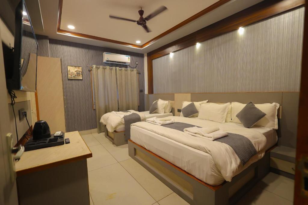 a bedroom with a large bed with a ceiling fan at Hotel Rohan Palace in Vrindāvan