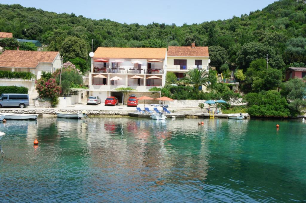 a house on a lake with boats in the water at Apartments Segedin in Korčula