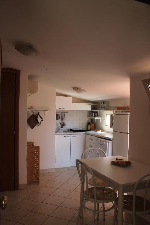 a kitchen with white appliances and a table and chairs at Mansarda 25 in Terracina