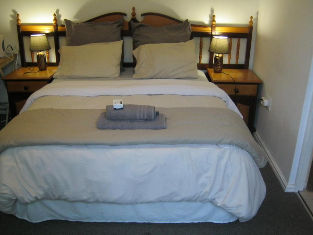 ブラッケンフェルにあるShirleys Placeのベッドルーム(白い大型ベッド、ランプ2つ付)