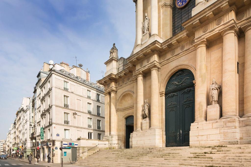 duży budynek z czarnymi drzwiami na ulicy w obiekcie Hôtel Londres Saint Honoré w Paryżu