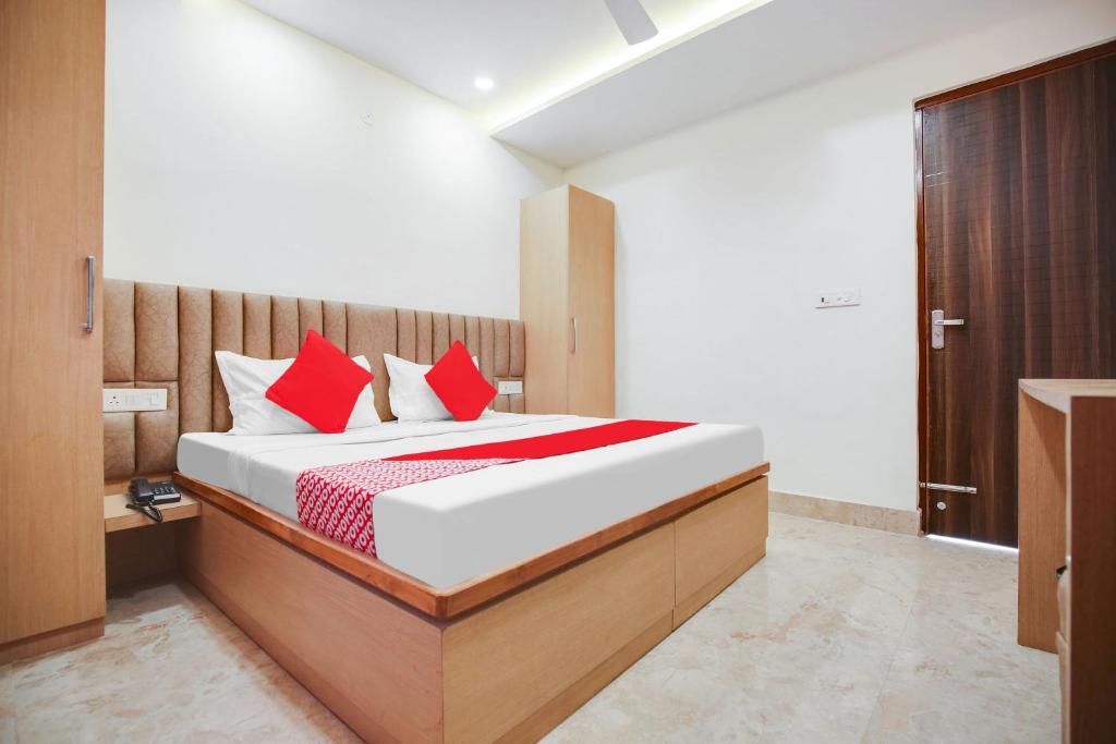 a bedroom with a large bed with red pillows at Hotel O Dhruva Residency in Ambāla