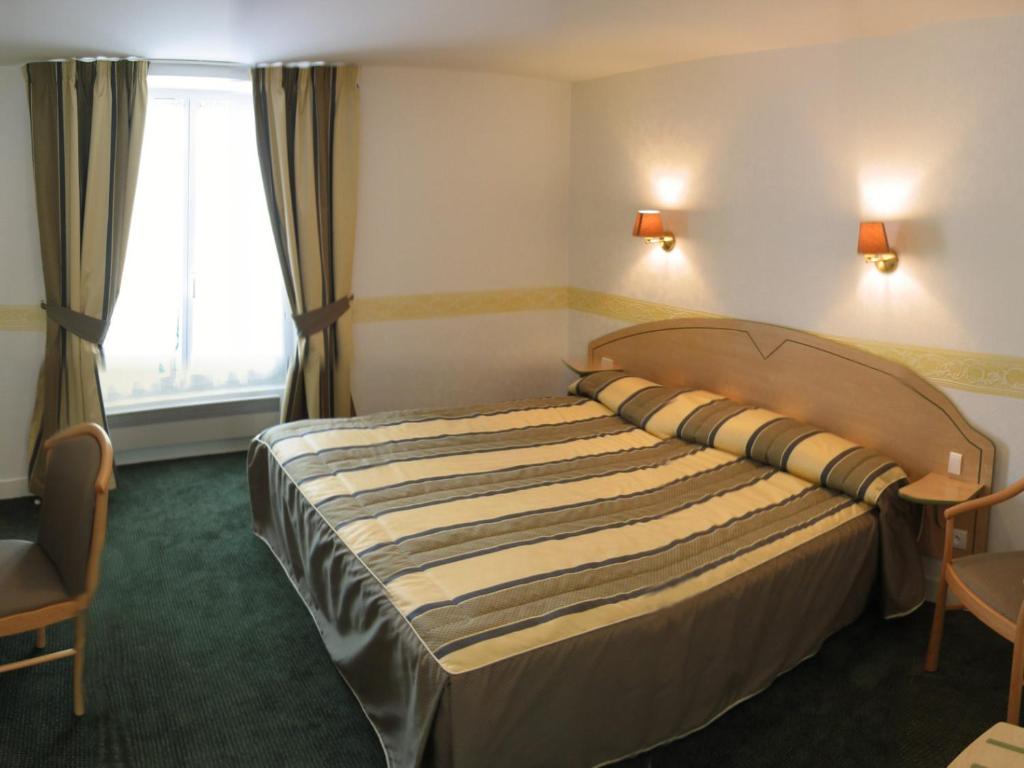 A bed or beds in a room at Logis Hôtel Restaurant La Boule d'Or