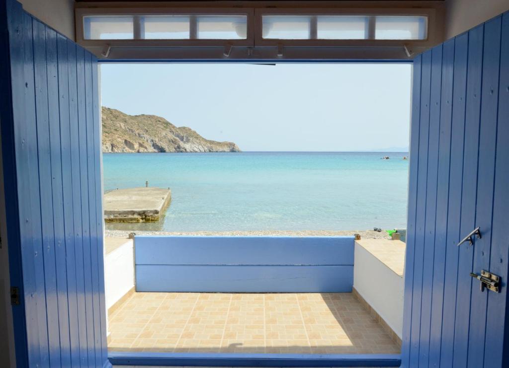 um quarto com vista para a praia através de uma porta em Erginas Boat House em Plaka