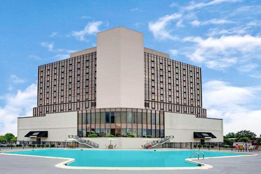 a hotel with a swimming pool in front of a building at Wyndham Garden Norfolk Downtown in Norfolk