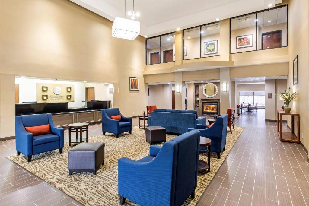 a lobby with blue chairs and a waiting room at Comfort Suites in Humble
