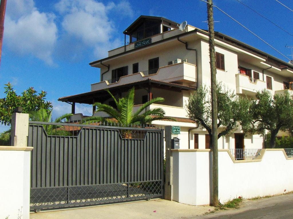 a white building with a fence in front of it at Residenza Giscor in Gasponi