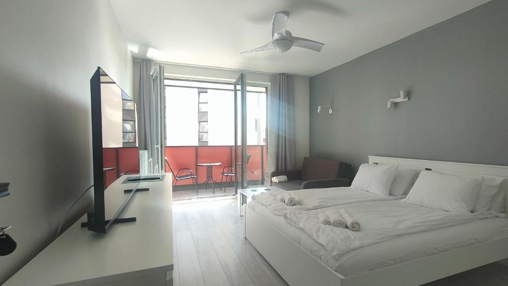 a bedroom with a bed and a room with a window at 2-Bedroom Apartment with 2 Free Parking Spots - TAURON ARENA in Kraków