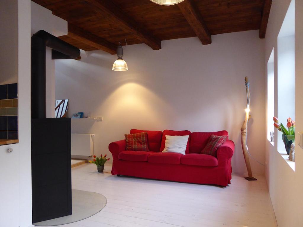 een woonkamer met een rode bank in een kamer bij StrandHafen in Otterndorf