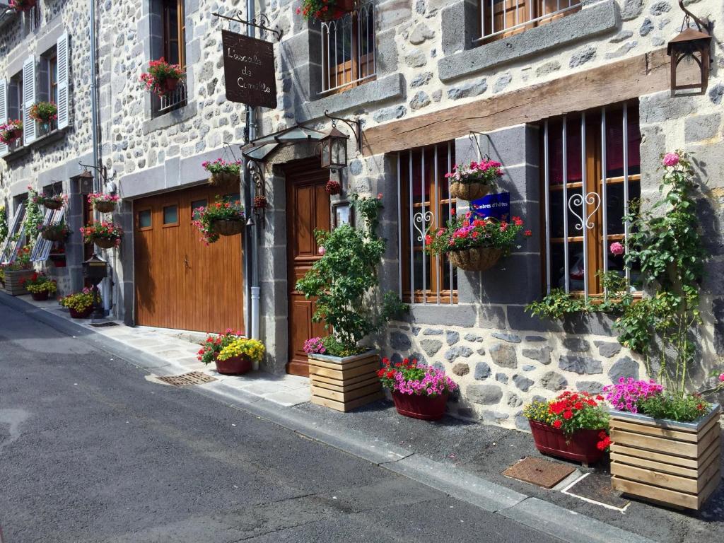 L'ESCALE DE CAMILLE في مورات: مبنى به نباتات الفخار على جانب الشارع