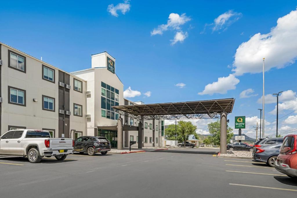 een parkeerplaats met auto's geparkeerd voor een gebouw bij Quality Inn Ruidoso in Ruidoso