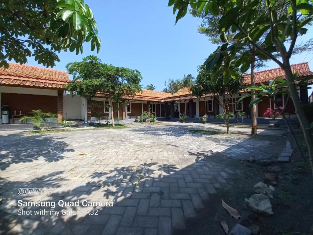 a courtyard of a school with trees and a building at Niti Guest House in Tegalan