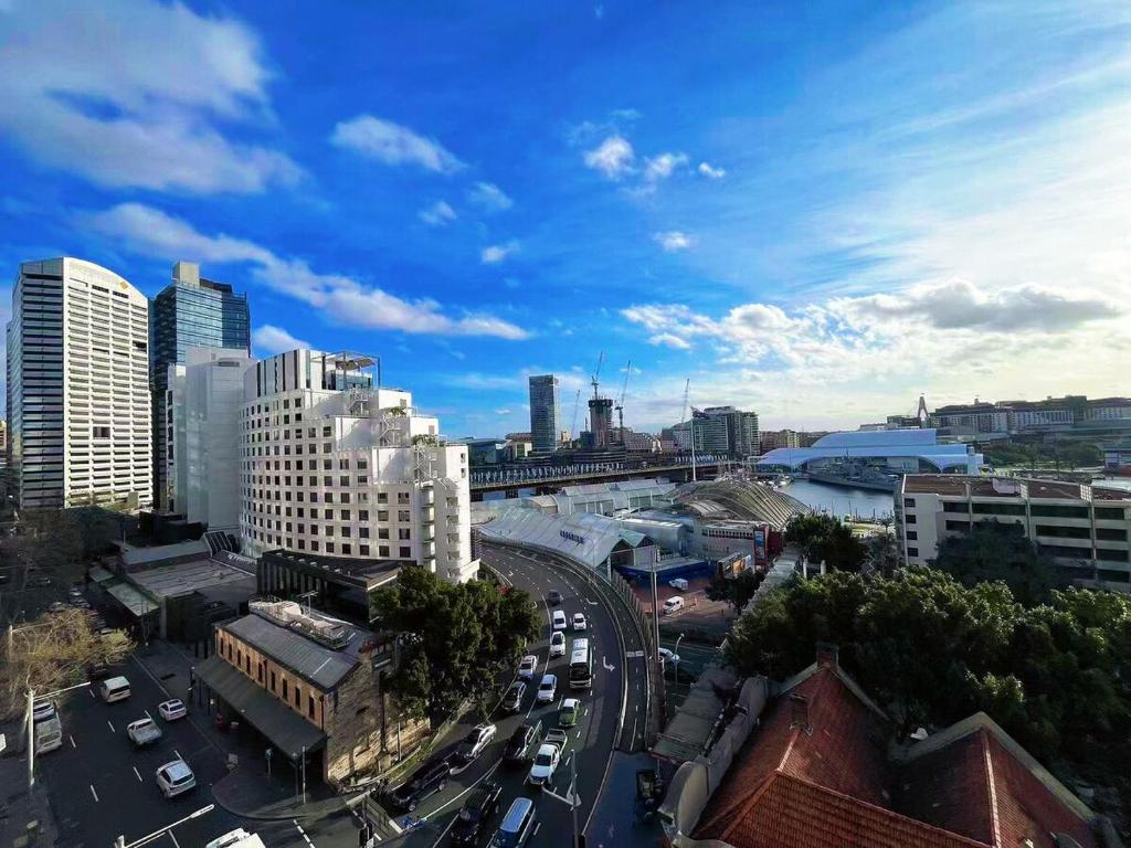 a city with a busy street with cars and buildings at Super Darling Harbour View in Sydney