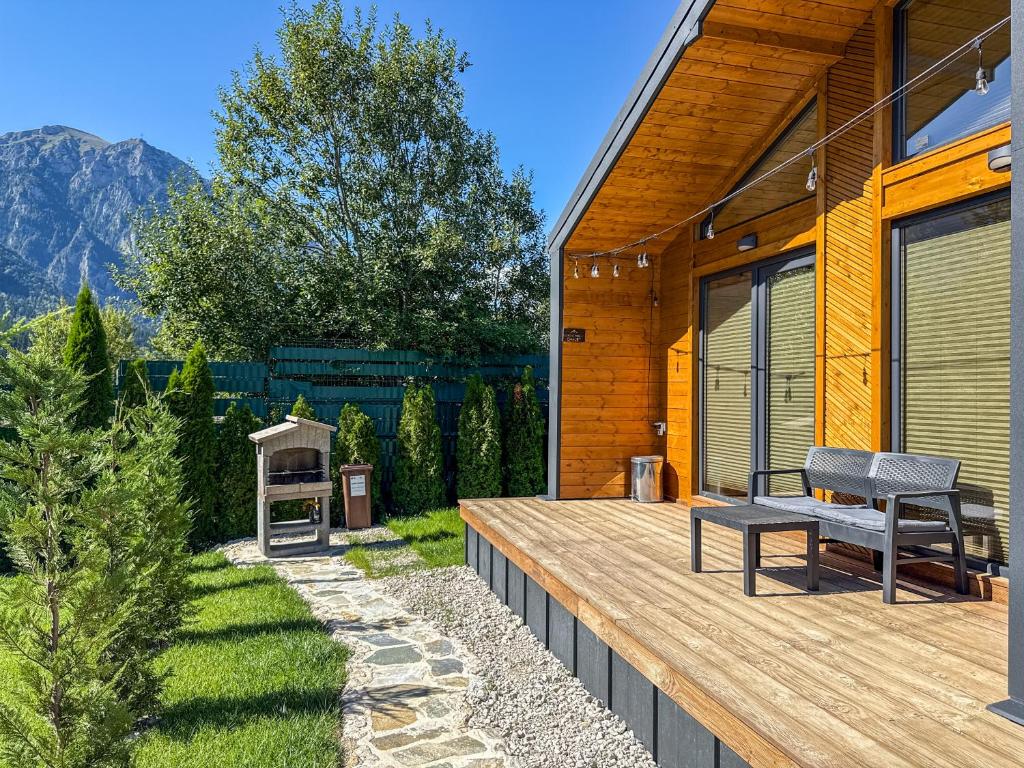 a wooden deck with a bench next to a house at Nordic Dream Chalet in Buşteni