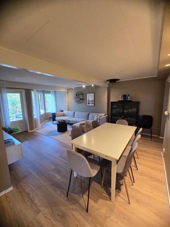 Un comedor y una sala de estar con mesa y sillas. en Nice and spacious apartment in a quiet area, en Tromsø