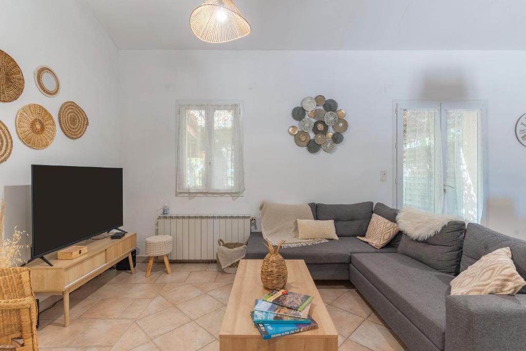 Una sala de estar con un sofá y un televisor de pantalla plana. en Domaine Plan Des Devens Sérénité, en Les Roussens