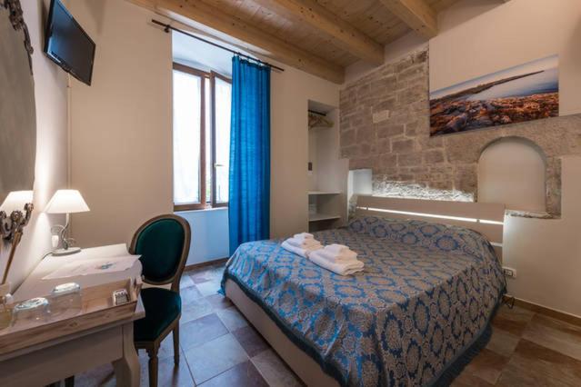 Habitación de hotel con cama, escritorio y escritorio. en B&B ANTICO GRANAIO en Bisceglie