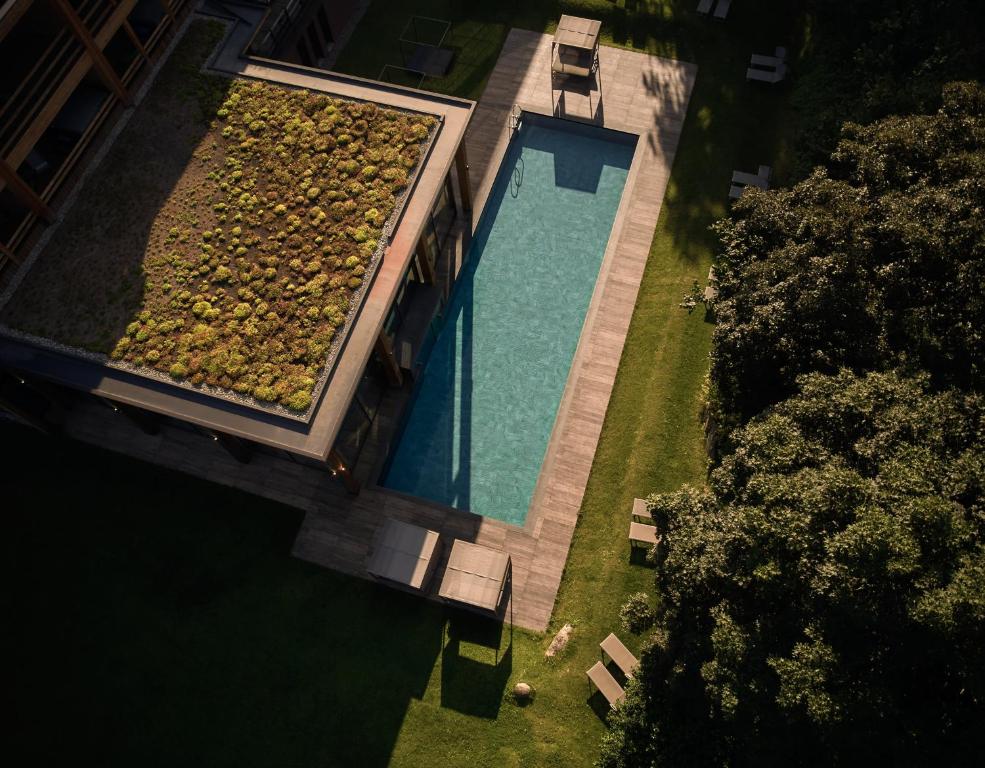 an overhead view of a swimming pool with a bunch of rocks at Hotel Pustertalerhof in Chienes