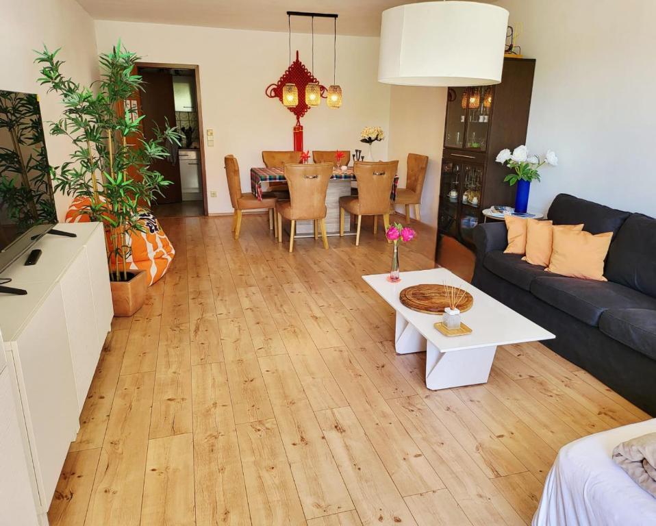 een woonkamer met een bank en een tafel bij Garden-Apartment next to the forest, free parking in Schonach