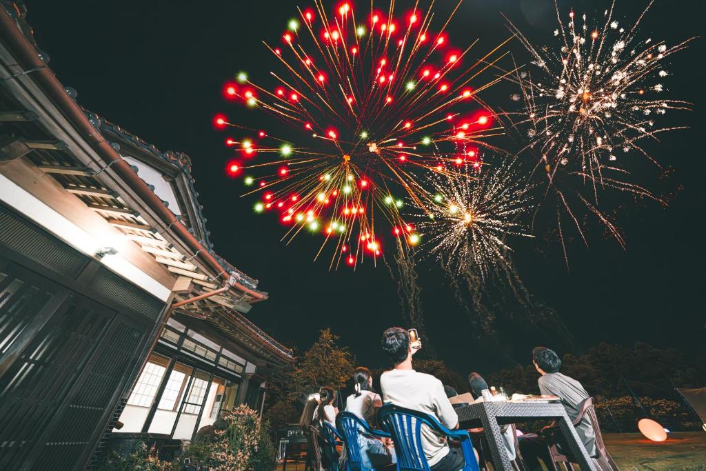 a group of people sitting at tables watching fireworks at HANABI棟 8人宿泊 サウナあり ペット不可 - Base棟 4人宿泊 サウナなし ペット可 - 貸切で最大12名宿泊OK in Katori