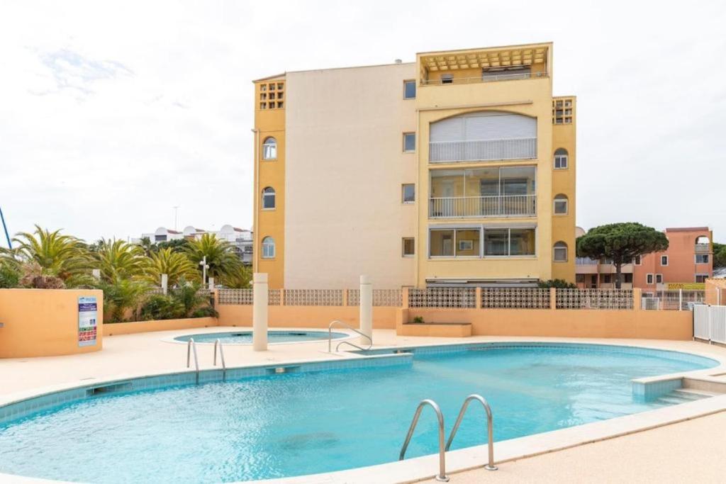 ein Schwimmbad vor einem Gebäude in der Unterkunft Le Nautilus in Gruissan