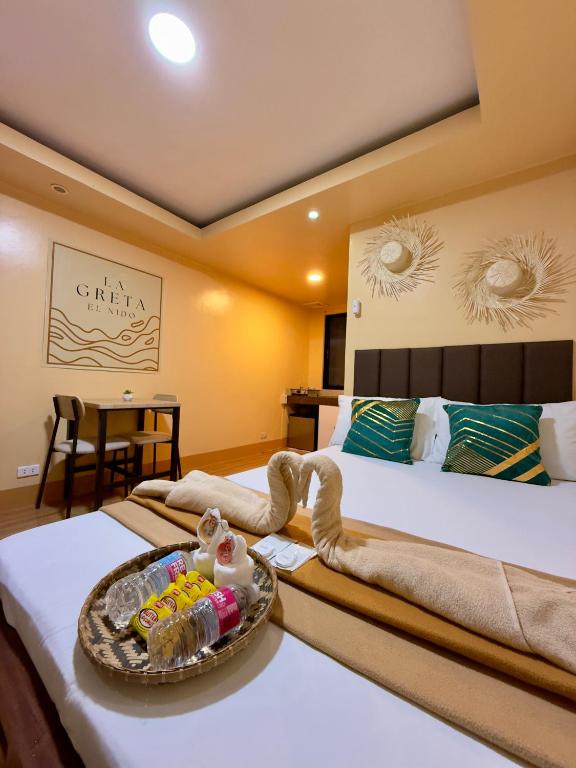 a hotel room with two beds and a tray of food at La Greta El Nido Apartments in El Nido