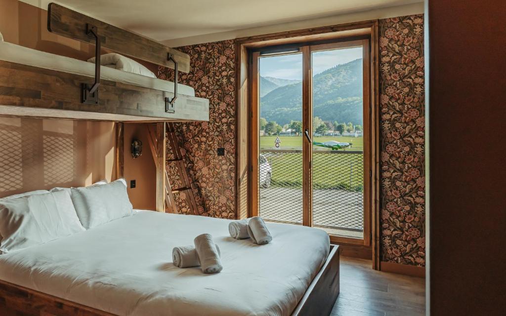 a bedroom with a bed and a large window at La Tour de Contrôle - Chambres & Appartements in Challes-les-Eaux
