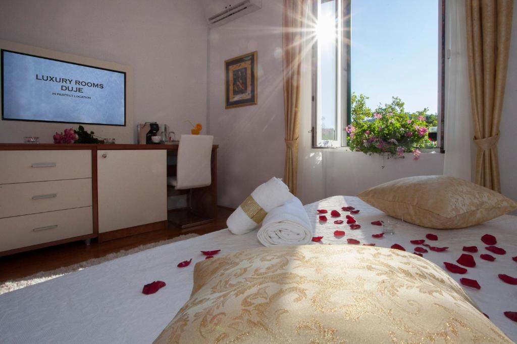 una camera da letto con un letto di rose sul pavimento di Luxury Rooms Duje a Spalato (Split)