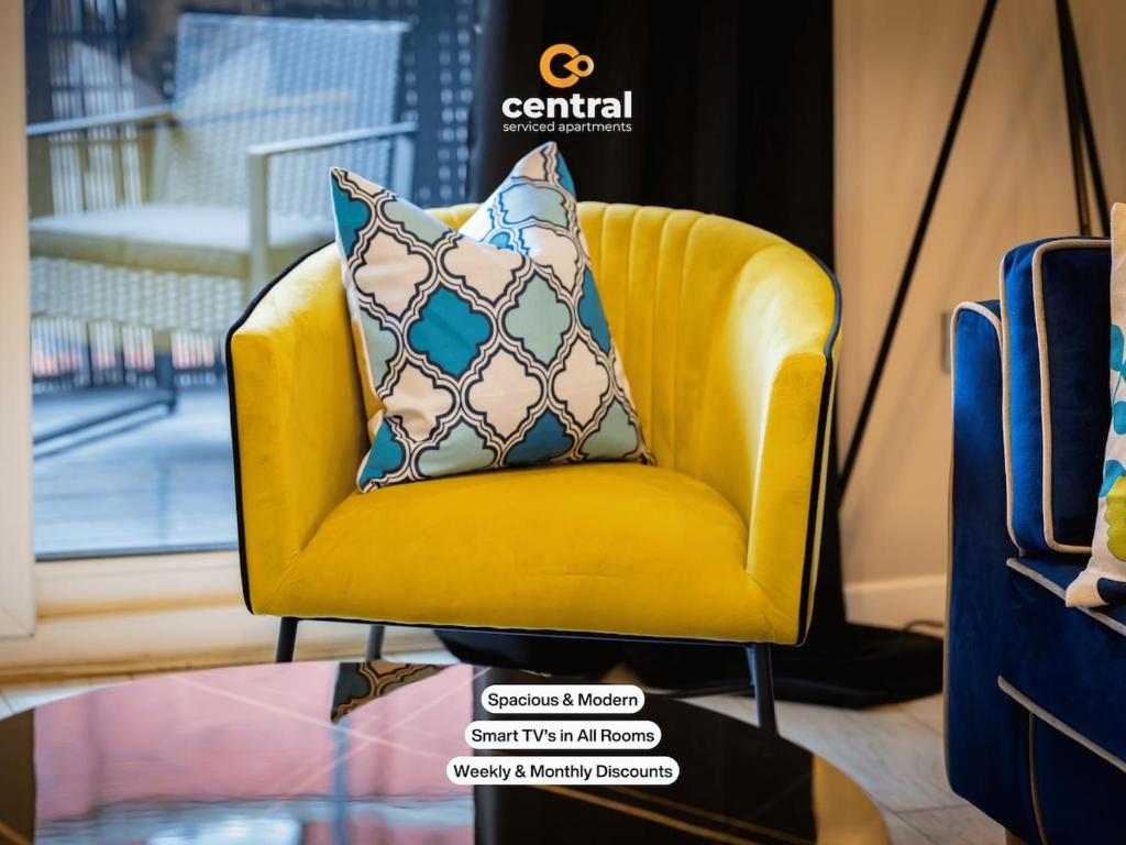 a yellow chair with a pillow on top of it at Trades Lane by CENTRAL SERVICED APARTMENTS - City Centre - 2 Bedrooms - En-Suite Bathroom - Dedicated Parking Space - Fully Equipped - Walk Away From Dundee Bus & Train Station - City Centre - Fully Equipped in Dundee