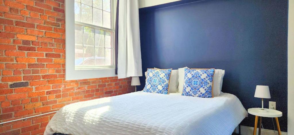 a blue bedroom with a bed with a brick wall at Jennifer's Historic Downtown Loft in Providence