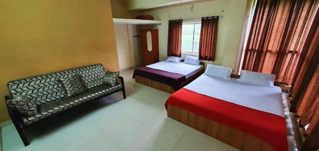 Glass House Yelagiri في ييلاجيري: غرفة فندقية تحتوي على سريرين وأريكة