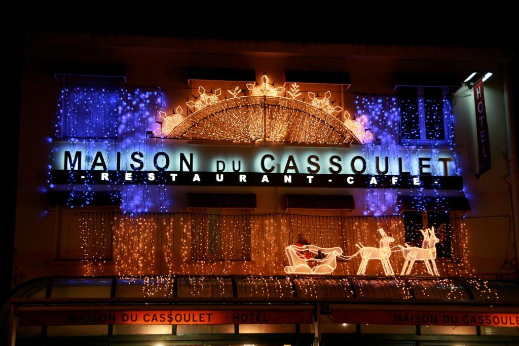 een gebouw met kerstverlichting en een bord erop bij Maison du Cassoulet in Castelnaudary