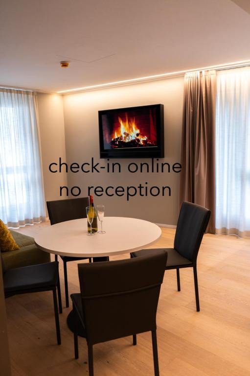 una mesa y sillas en una habitación con chimenea en Arbed Living Hotel SELF CHECK IN - Supercharger - Fitness Bellinzona, en Bellinzona