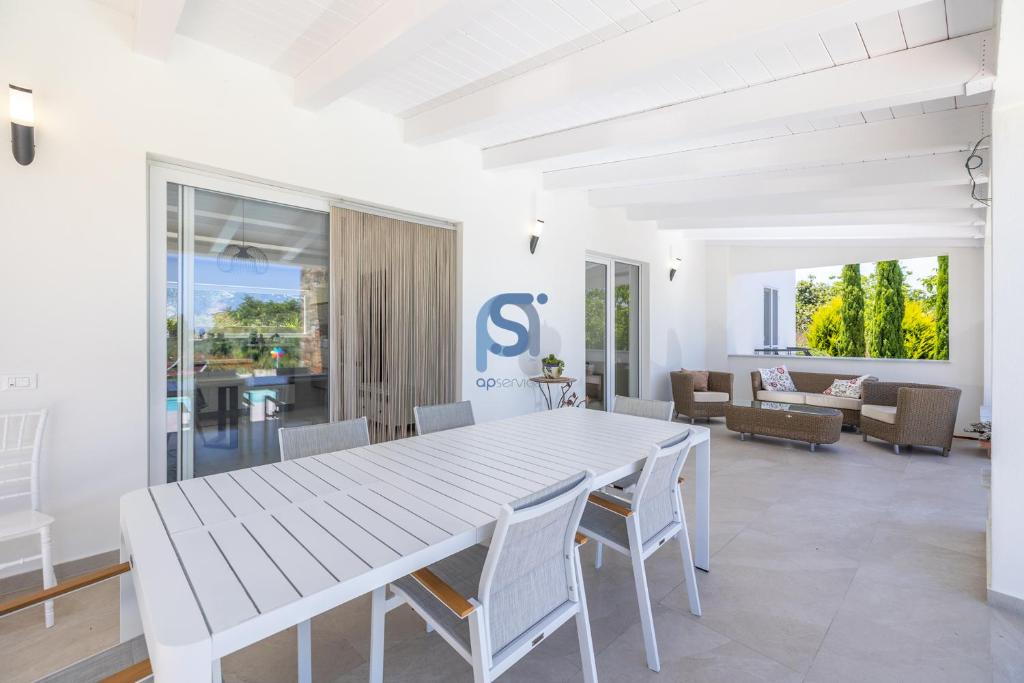 une salle à manger blanche avec une table et des chaises blanches dans l'établissement Villa Irene Deluxe, à Campofelice di Roccella