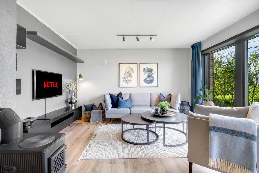 a living room with a couch and a table at Spacious Arctic Apartment Near Tromsøs Top Sights in Tromsø