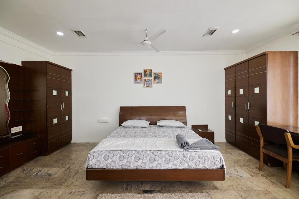 a bedroom with a large bed and wooden cabinets at LakeView Penthouse Room Himayatnagar in Lingampalli