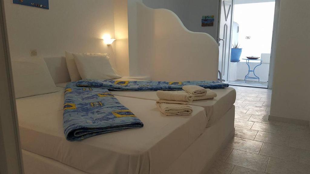 two beds in a room with towels on them at Ostria Vento in Pollonia