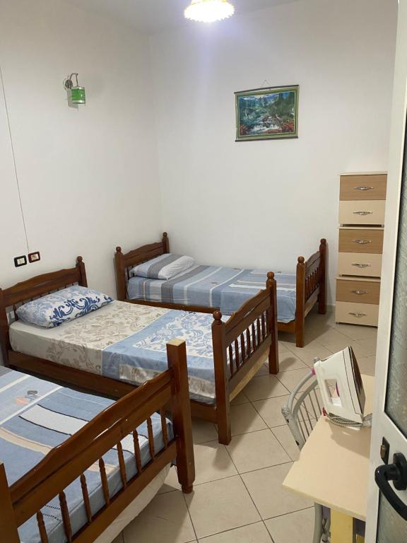 Cette chambre comprend 3 lits et un bureau. dans l'établissement Ndrezaj House, à Shkodër