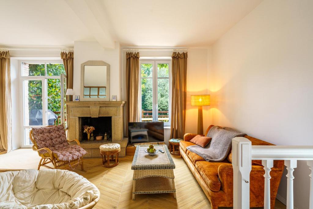 a living room with a couch and a fireplace at Ker Gaïdic - Proche Plage in Bénodet
