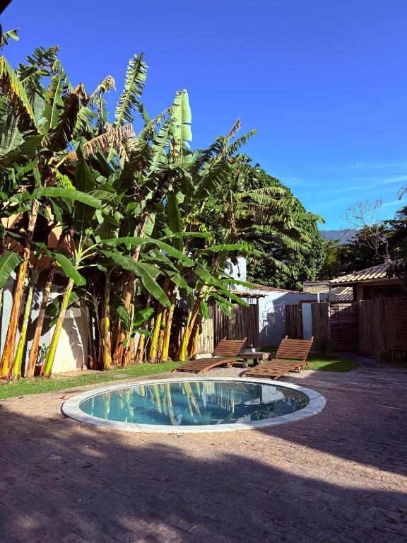 a small pool in the middle of a yard with trees at Gizele Sander Arte & Hospedagem in Ilhabela