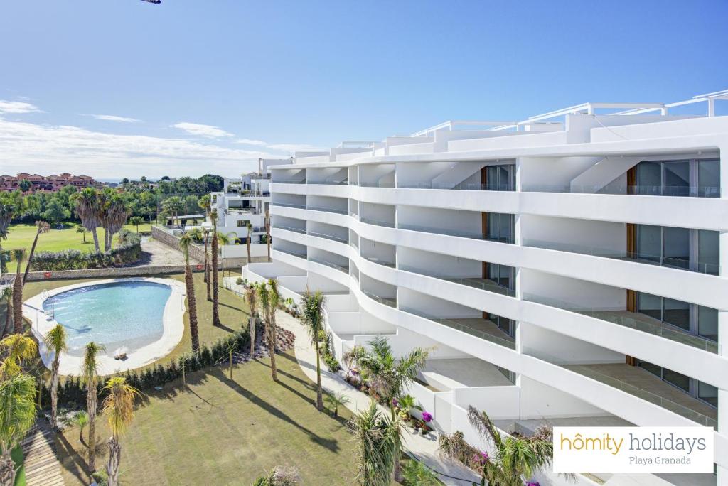 an aerial view of a building with a swimming pool at Homity Holidays - Playa Granada - Mar de Fabiola in Motril