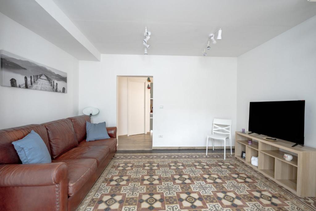 a living room with a brown couch and a flat screen tv at Gabbiano 2 - Sea Loft in Bari