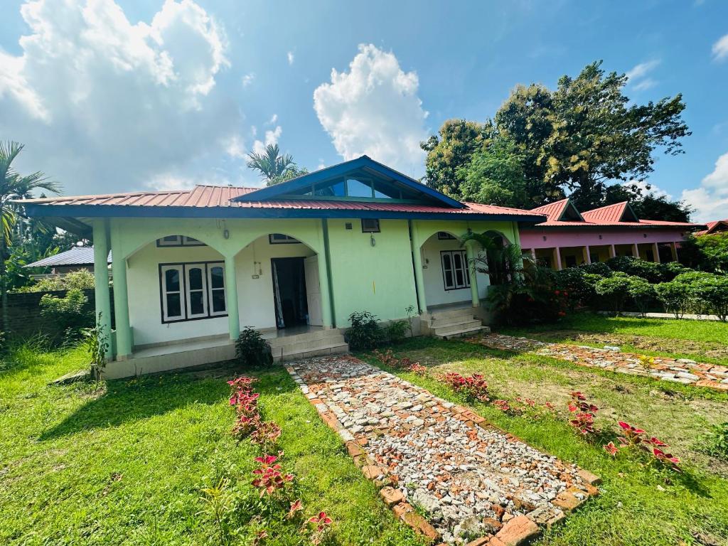 a small house with a garden in front of it at New Kaziranga Cottage in Kāziranga