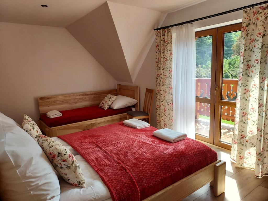 a bedroom with two beds and a large window at Apartamenty Drewutnia w Wiśle in Wisła