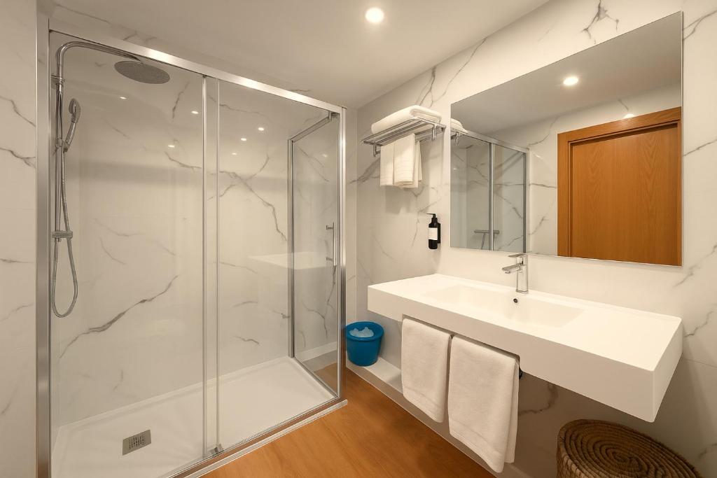 een badkamer met een wastafel en een douche bij Apartamentos Sevilla Palace in Sevilla