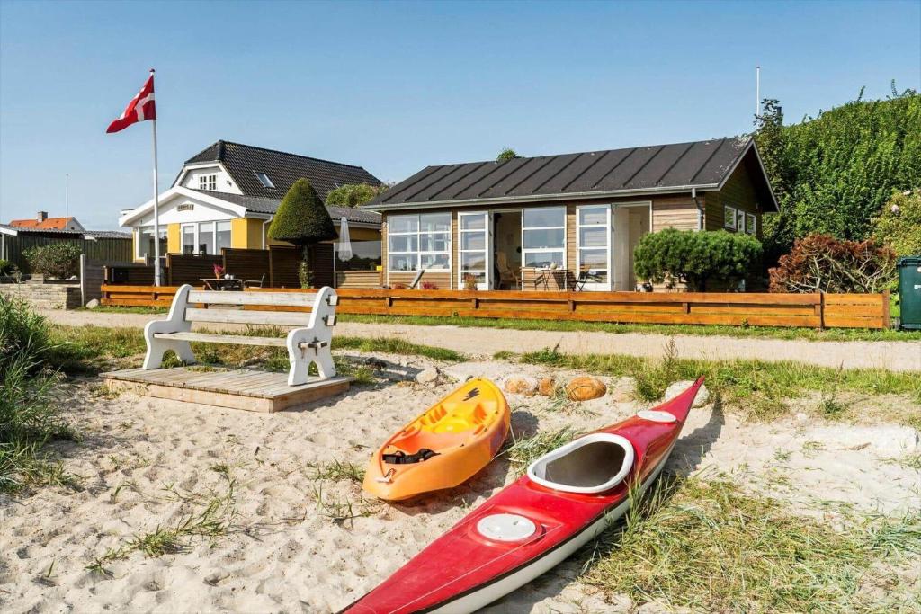 un kayak rosso appoggiato sulla sabbia davanti a una casa di SJ271-Hejls-Ved-Kysten-2 a Hejls