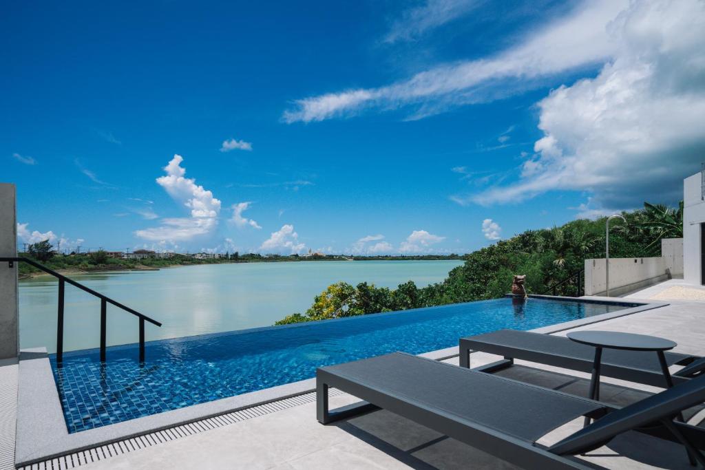 宮古島にあるVilla M BAYFRONT YONAHA -Pool&Sauna Retreat-の水辺の景色が見えるプール