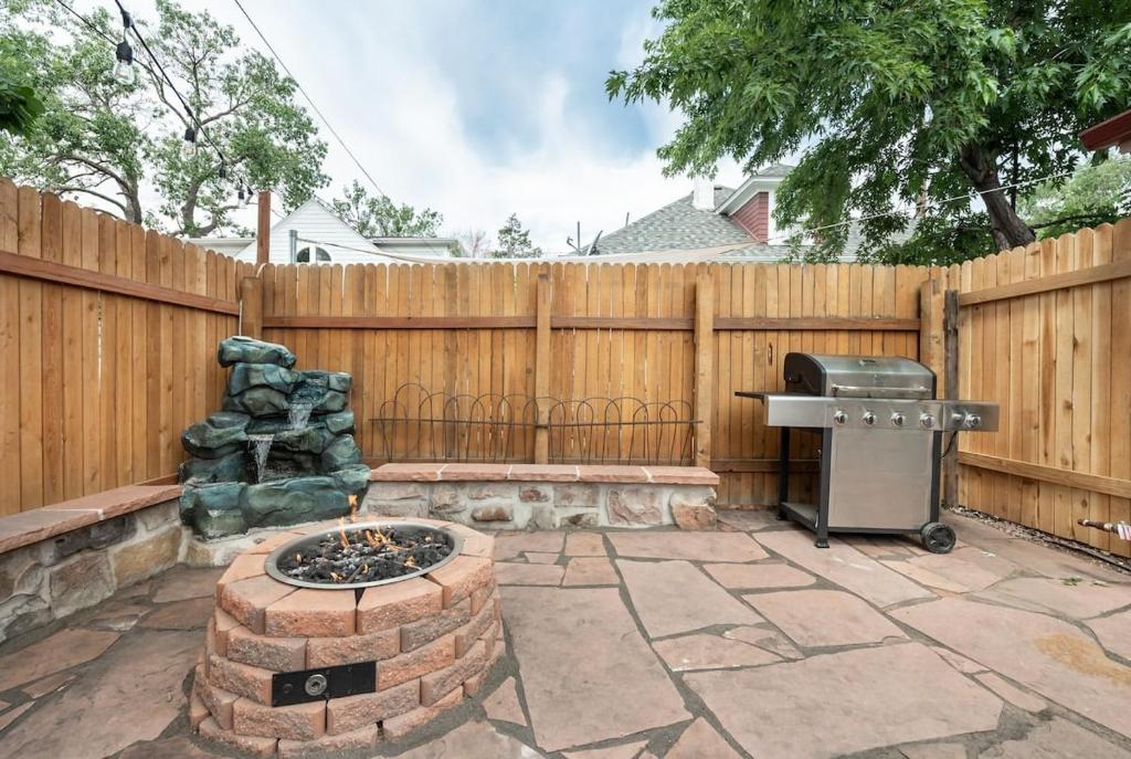een achtertuin met een vuurplaats en een hek bij Downtown Oasis - Steps to Dining, Cafes & Bars in Colorado Springs