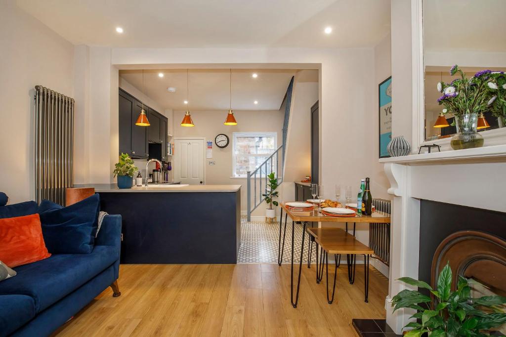 ein Wohnzimmer und eine Küche mit einem blauen Sofa in der Unterkunft Lockwood Cottage, Close to Monk Bar, sleeps 4 in York