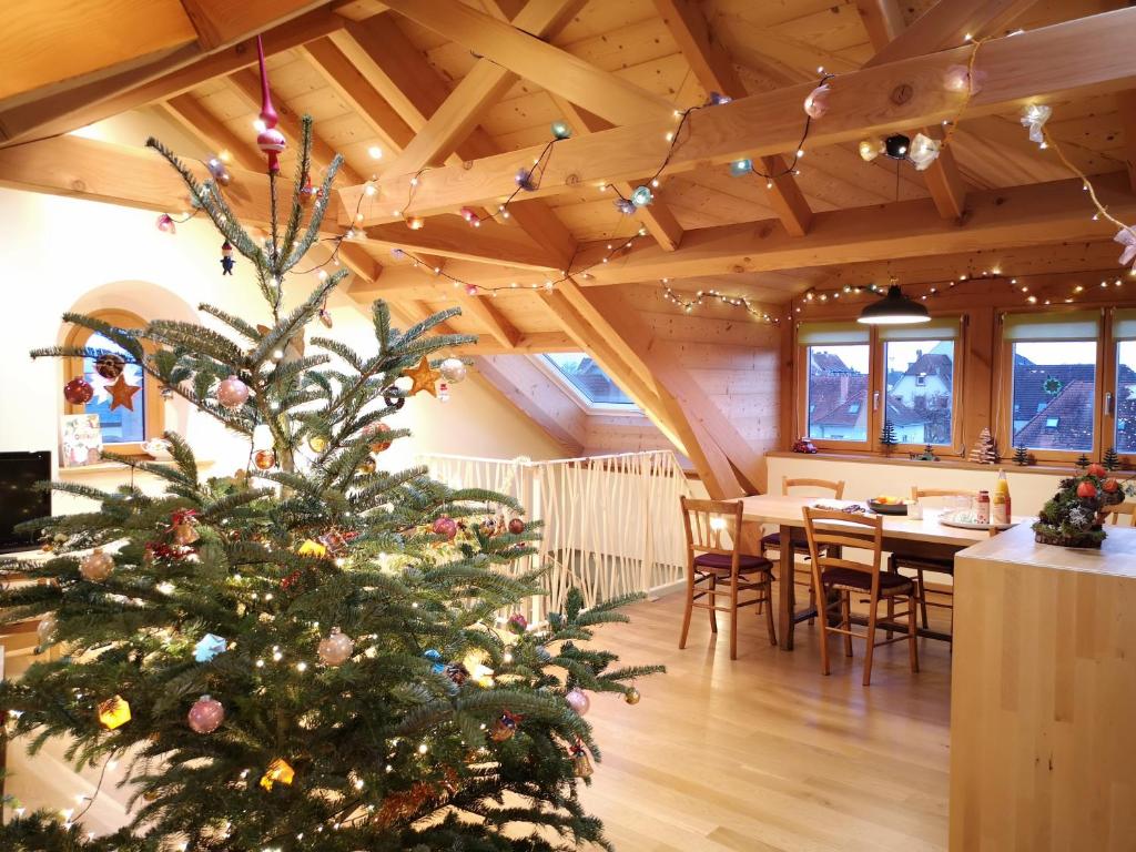 コルマールにあるColmar Friends and Familly guest home - ALL INCLUSIVE - COLMAR Gare - Jardin - Combles et Vousのダイニングルーム付きの部屋のクリスマスツリー